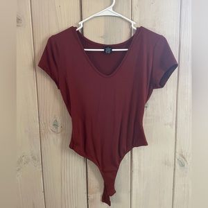 Burnt orange body suit.